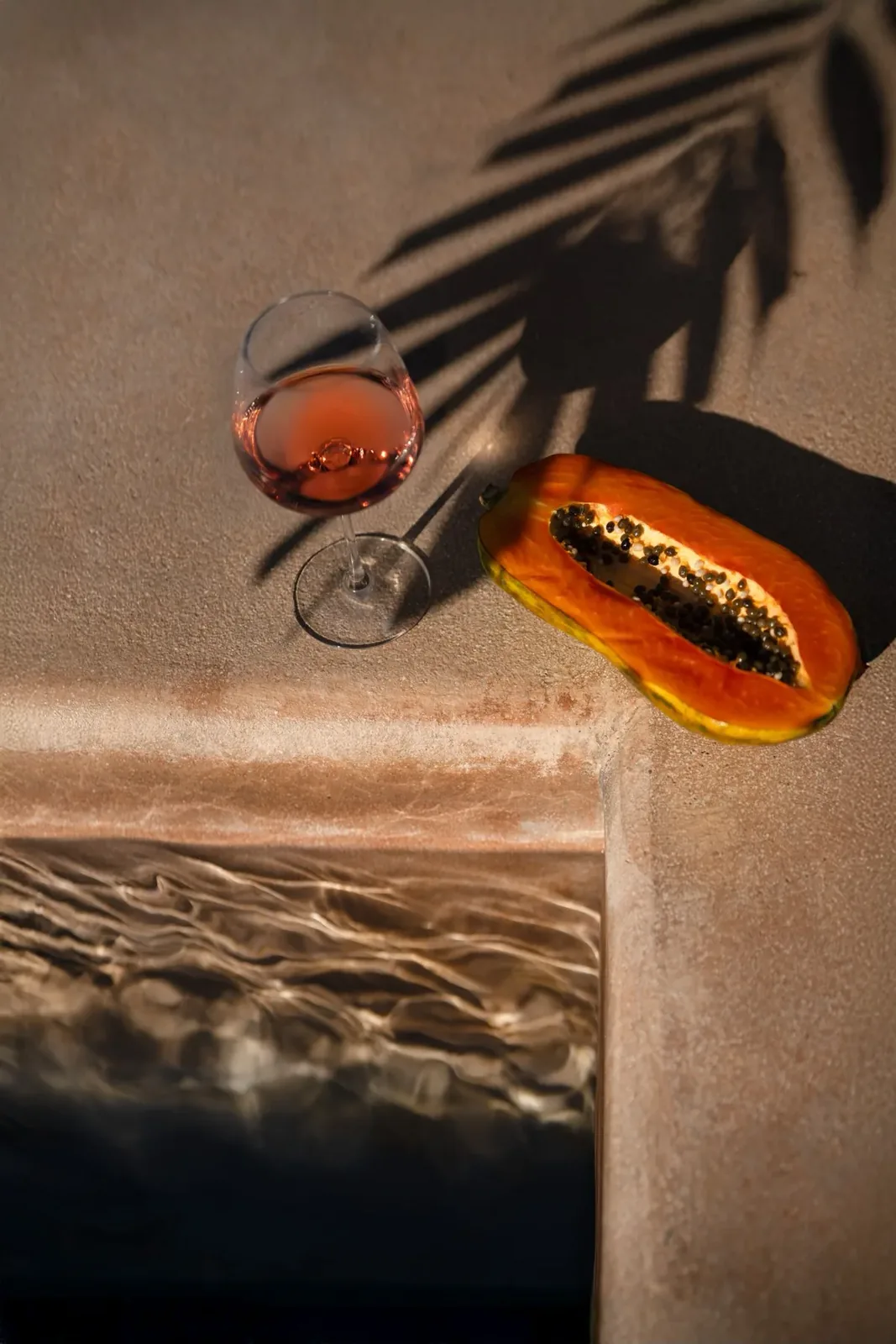 Spaces and architecture: wine and papaya, poolside still life