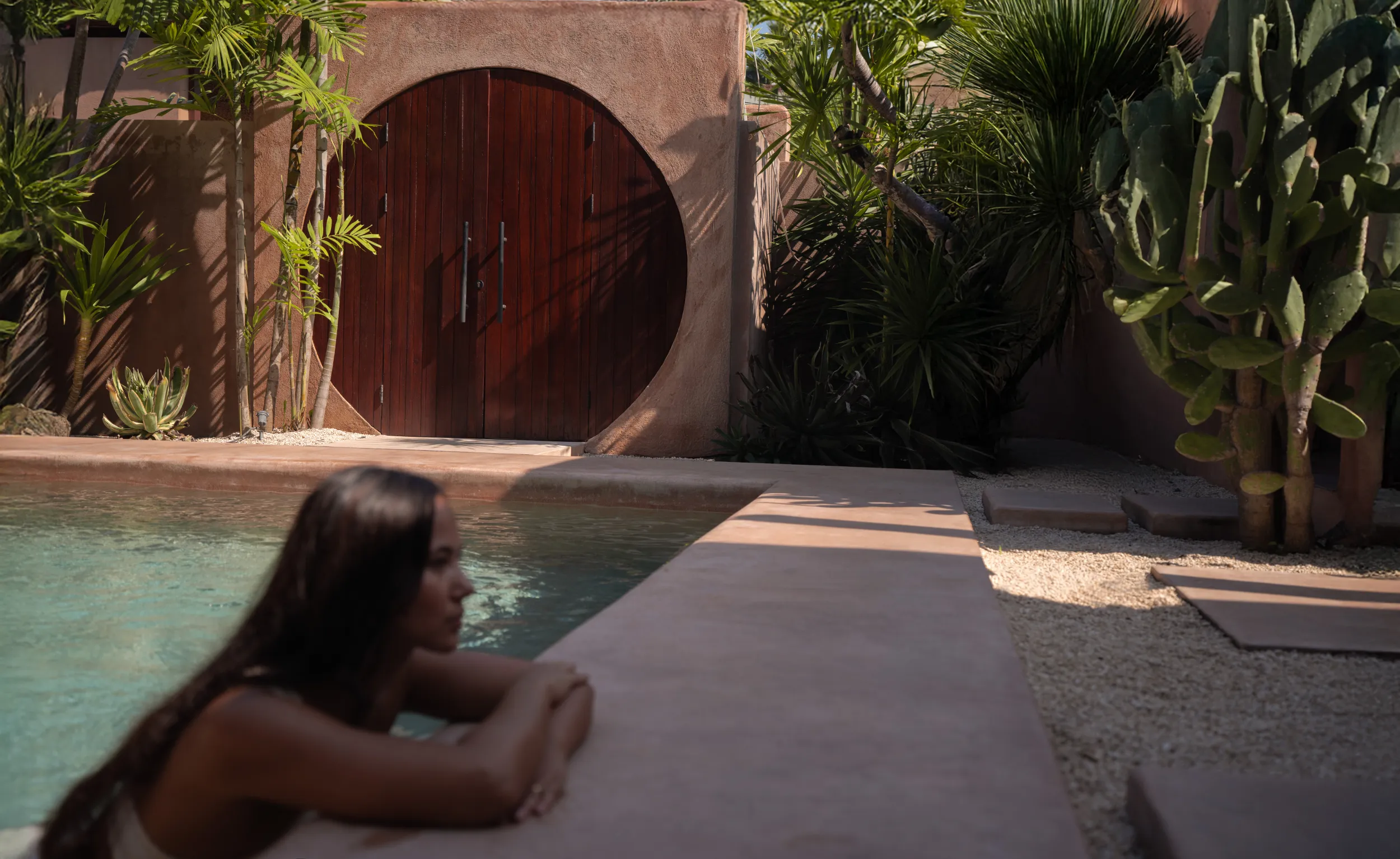 Editorial lifestyle: woman by a desert archway, villa architecture