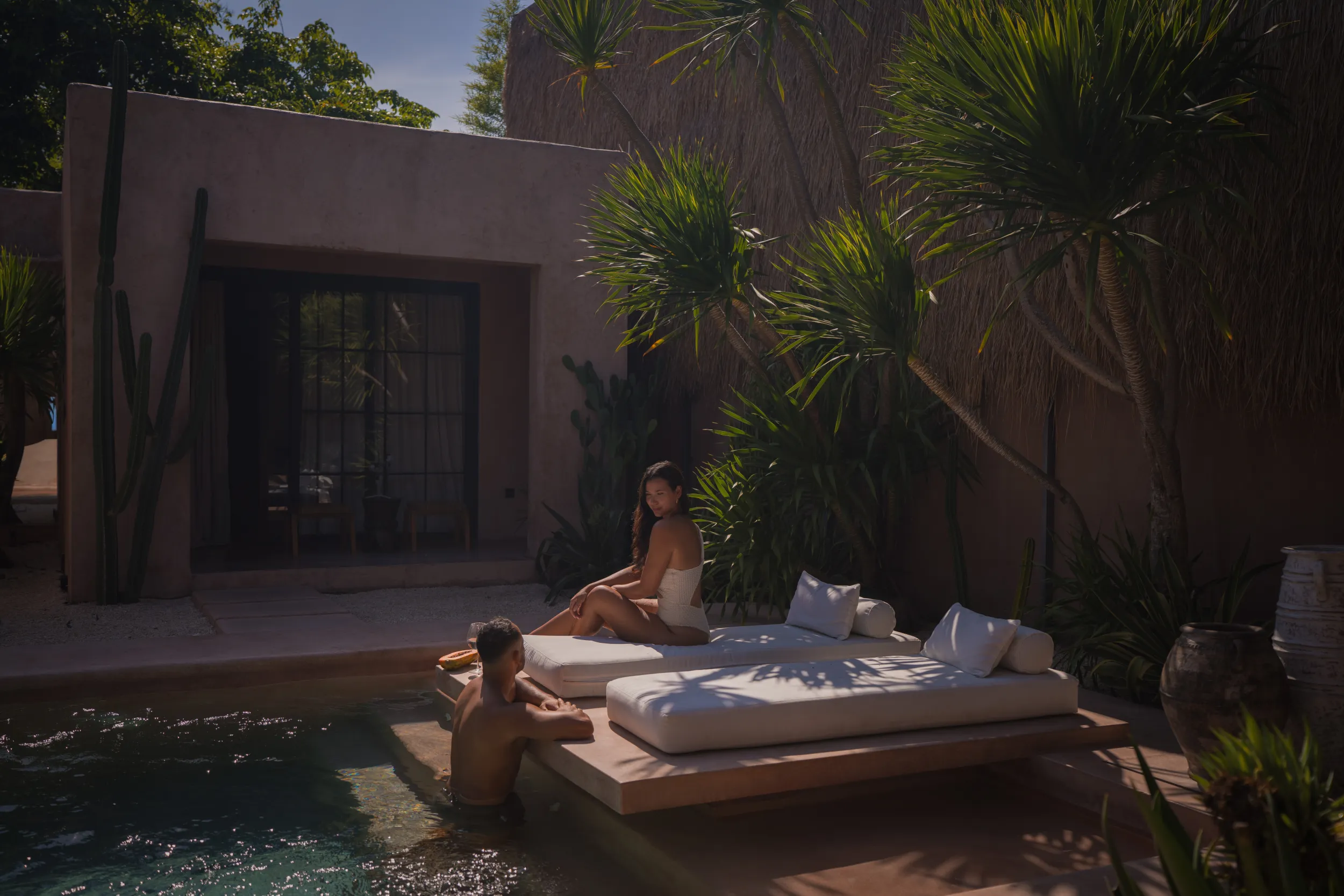 Couple at ease on a poolside daybed: byduran hospitality photography