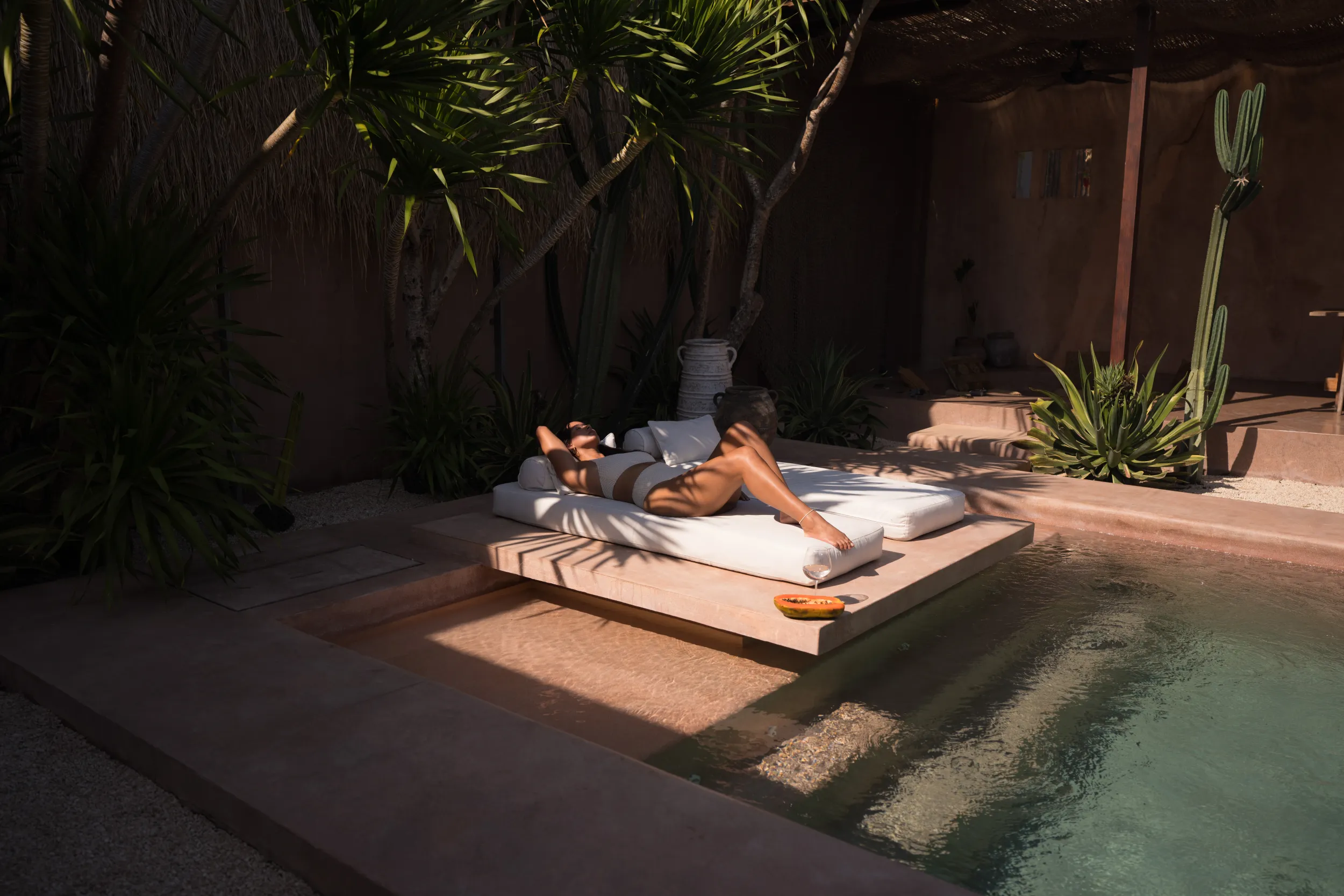 Editorial lifestyle: woman resting on a poolside daybed