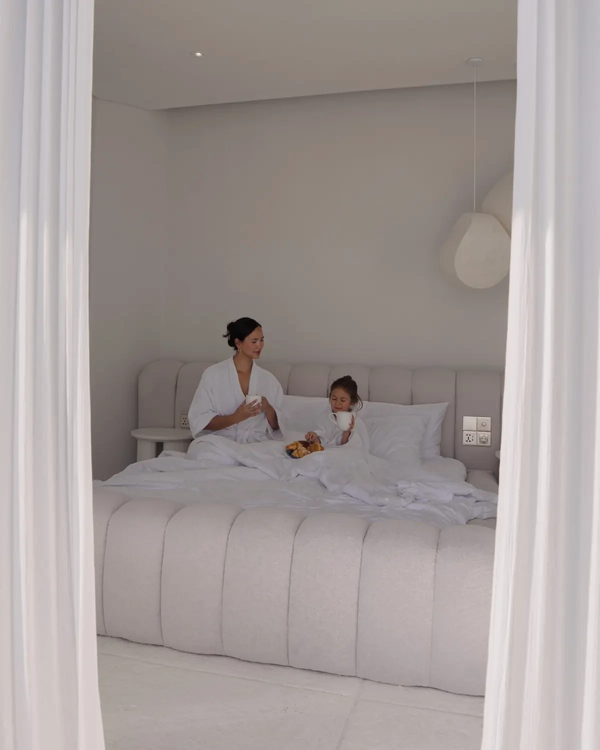Mother and daughter sharing breakfast in bed
