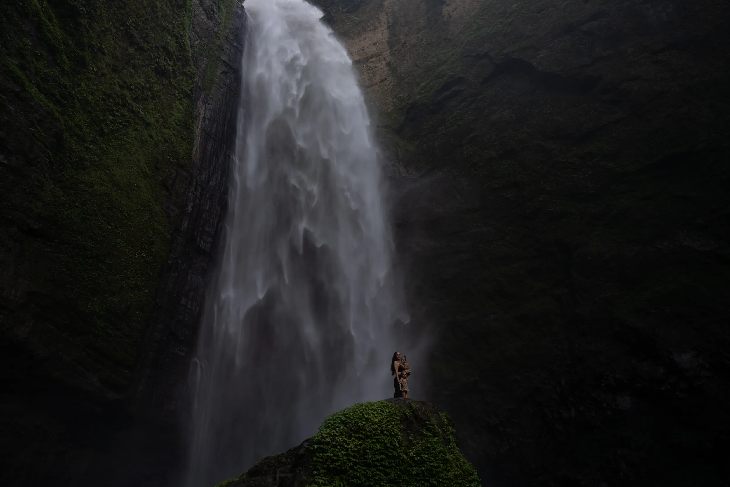 Sense of place: waterfall, distant figures on a mossy ledge